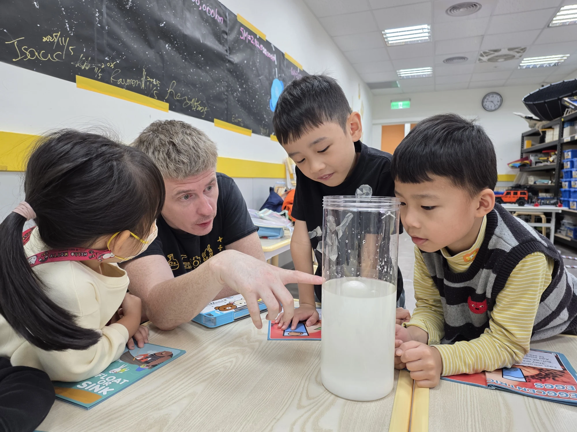 Tr. Paul guiding students through a hands-on science activity at STEAM SQUAD