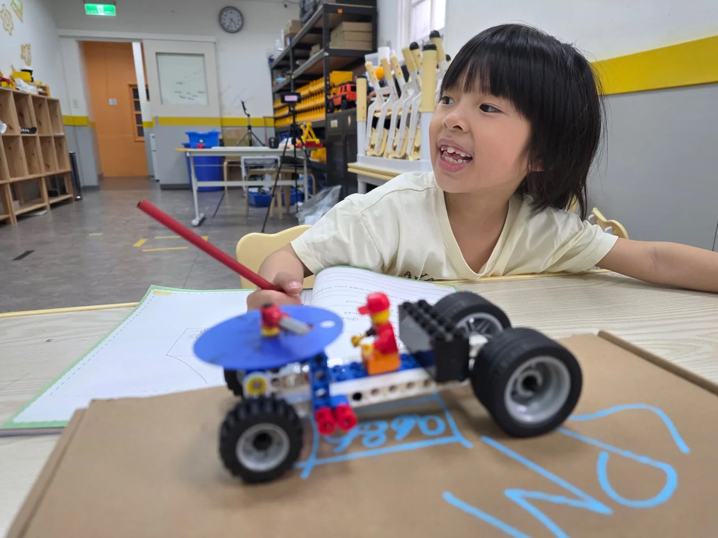 A student proudly showing a LEGO engineering project