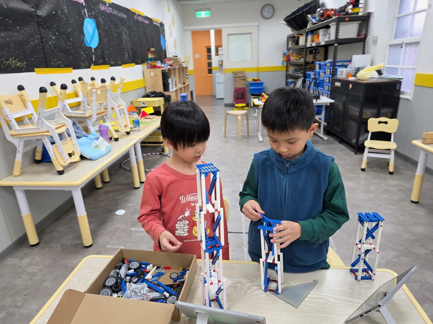 Two students collaborating on a tall engineering structure